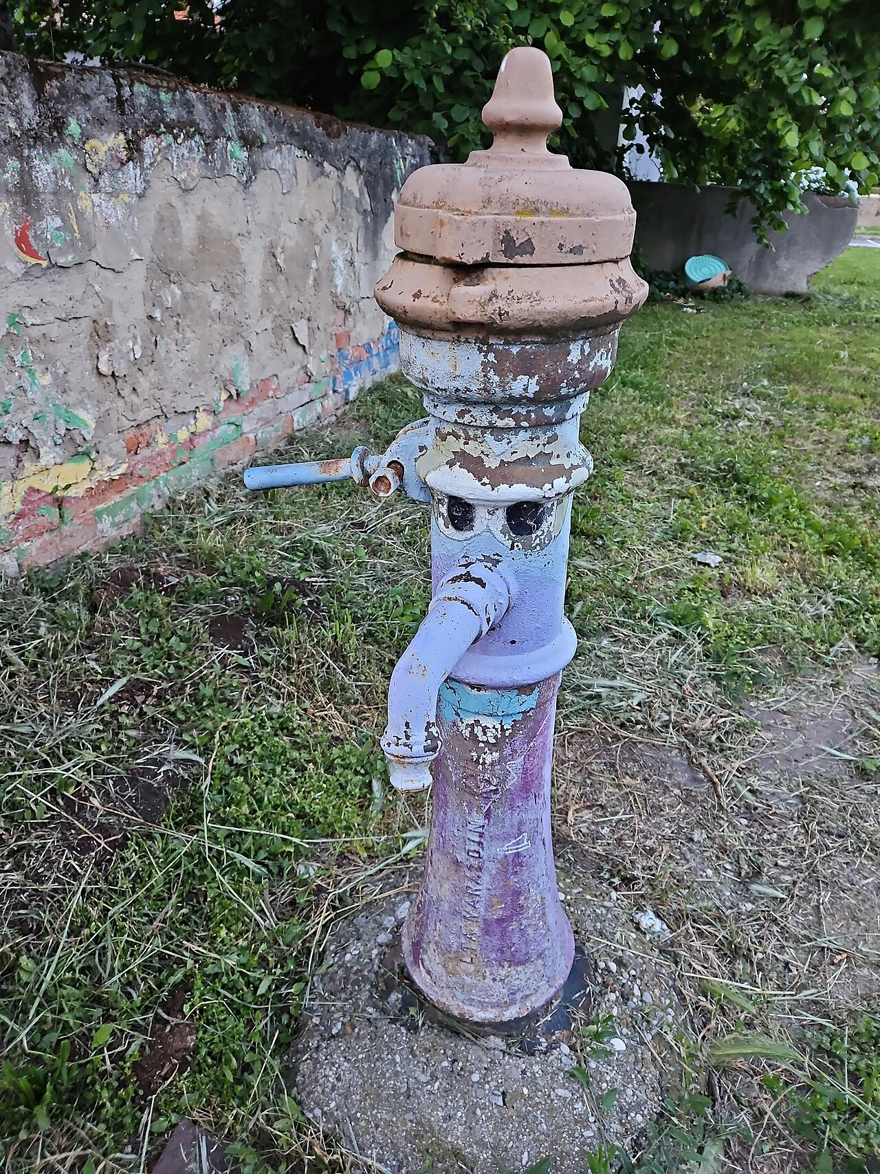 Pumpa oslikana licem u Kraljevečkoj ulici, s vidljivim trošenjem boje.